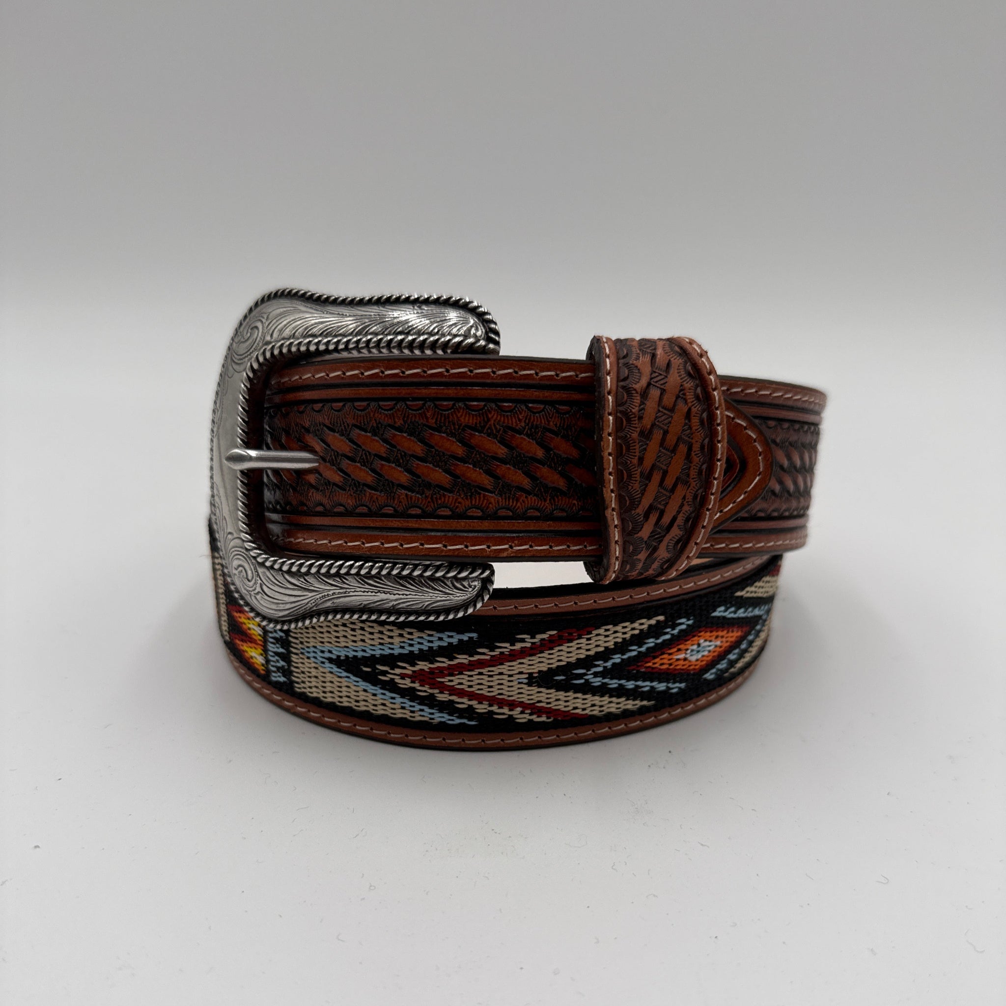Brown leather belt with decorative buckle on a light gray background