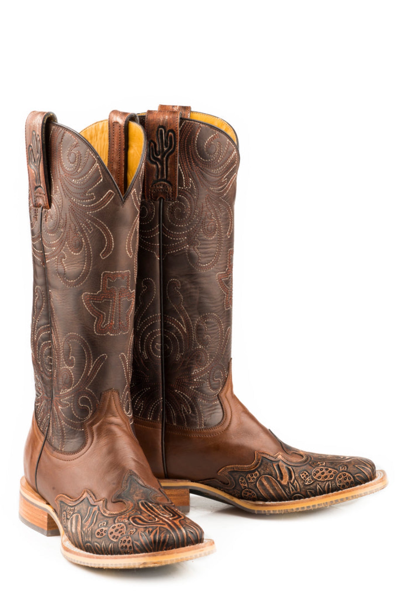 Pair of brown cowboy boots with intricate designs on a white background