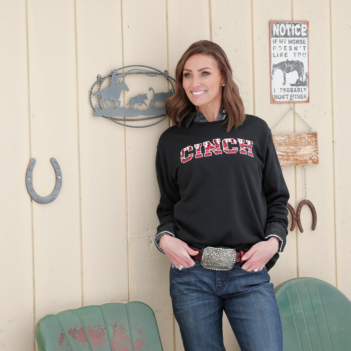  black hoodie with 'CINCH' branding in a rustic setting.