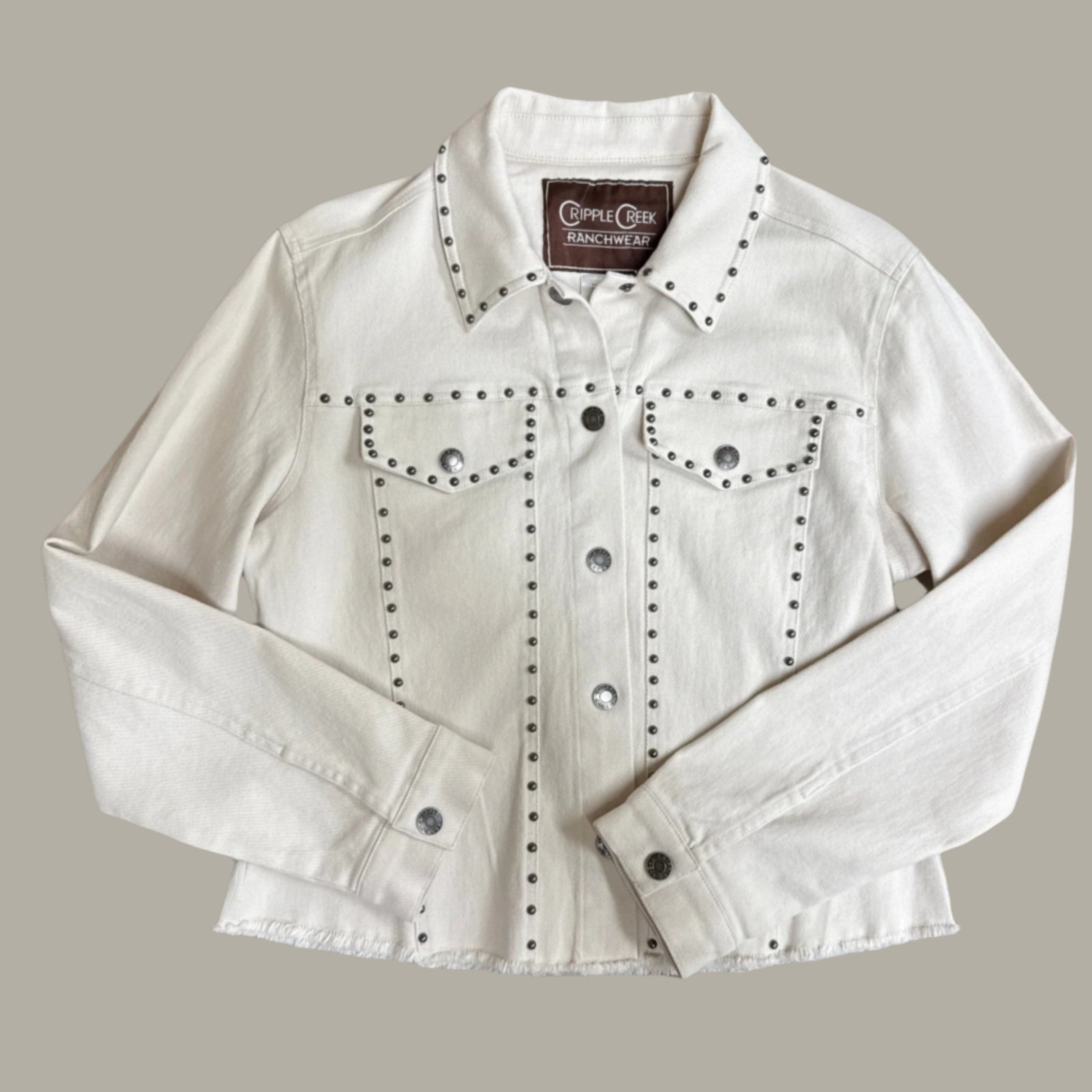 Cream denim jacket with studded details and snap front and cuffs