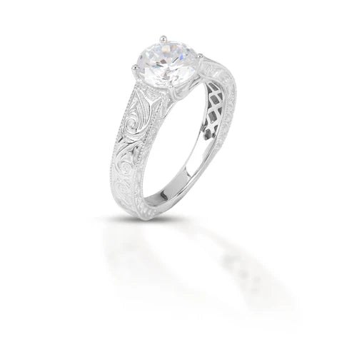 Silver ring with intricate design and a central diamond 