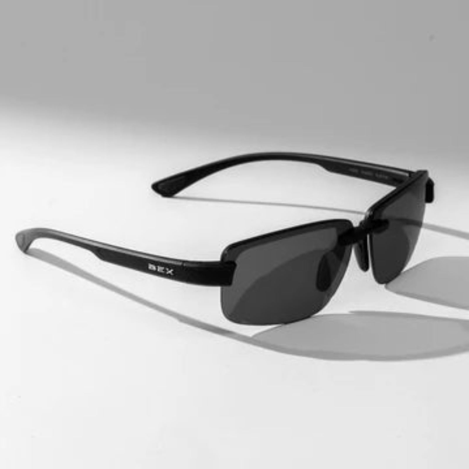 Black sunglasses with a brand logo on a light gray background