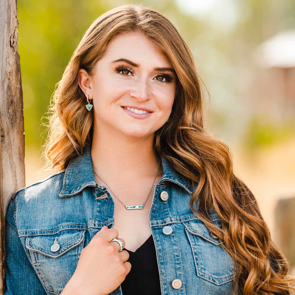 Woman wearing a denim jacket with a blurred natural background