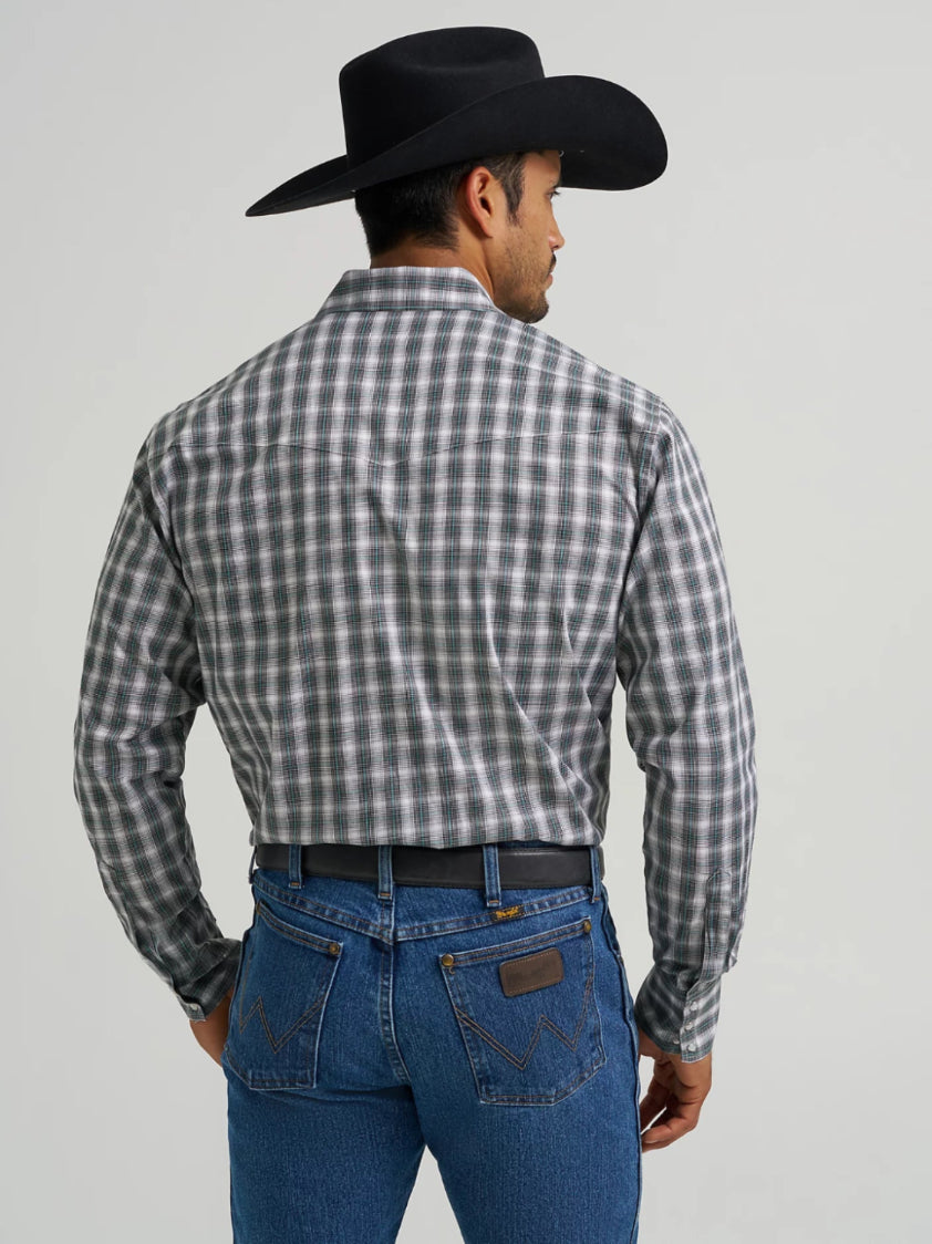Man wearing a black and white checkered shirt, blue jeans, and a black cowboy hat on a gray background