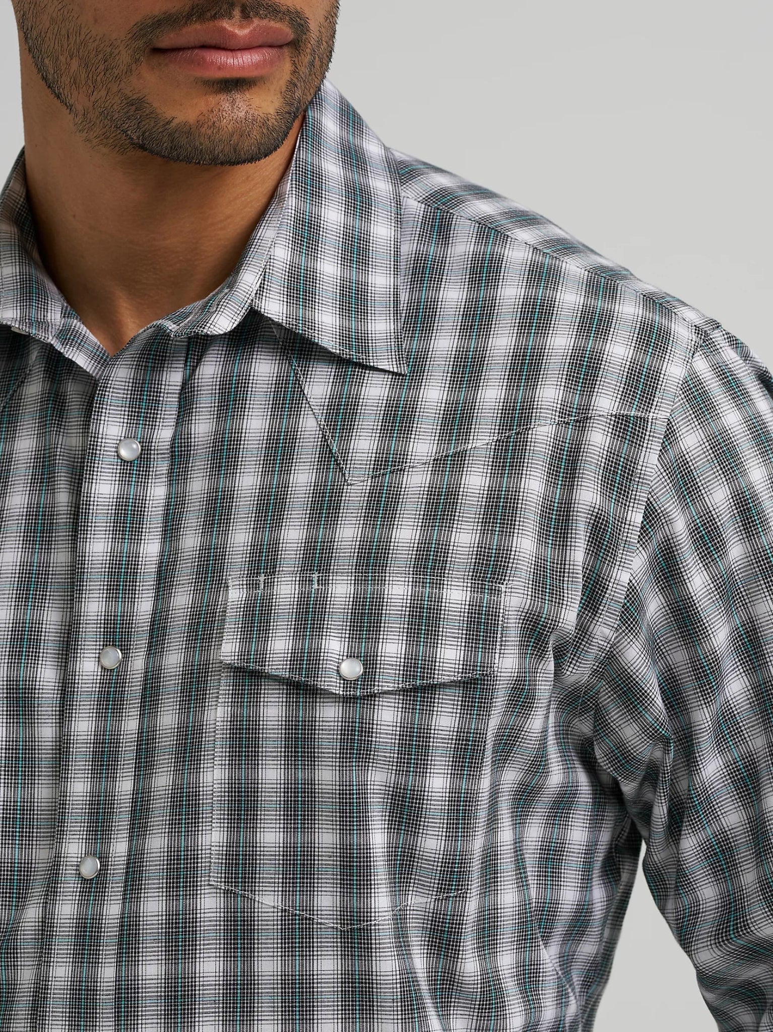 Man wearing a blue and white plaid shirt against a white background