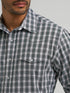 Man wearing a blue and white plaid shirt against a white background