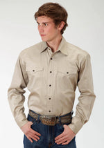 Man wearing a beige long-sleeve shirt with a belt on a white background