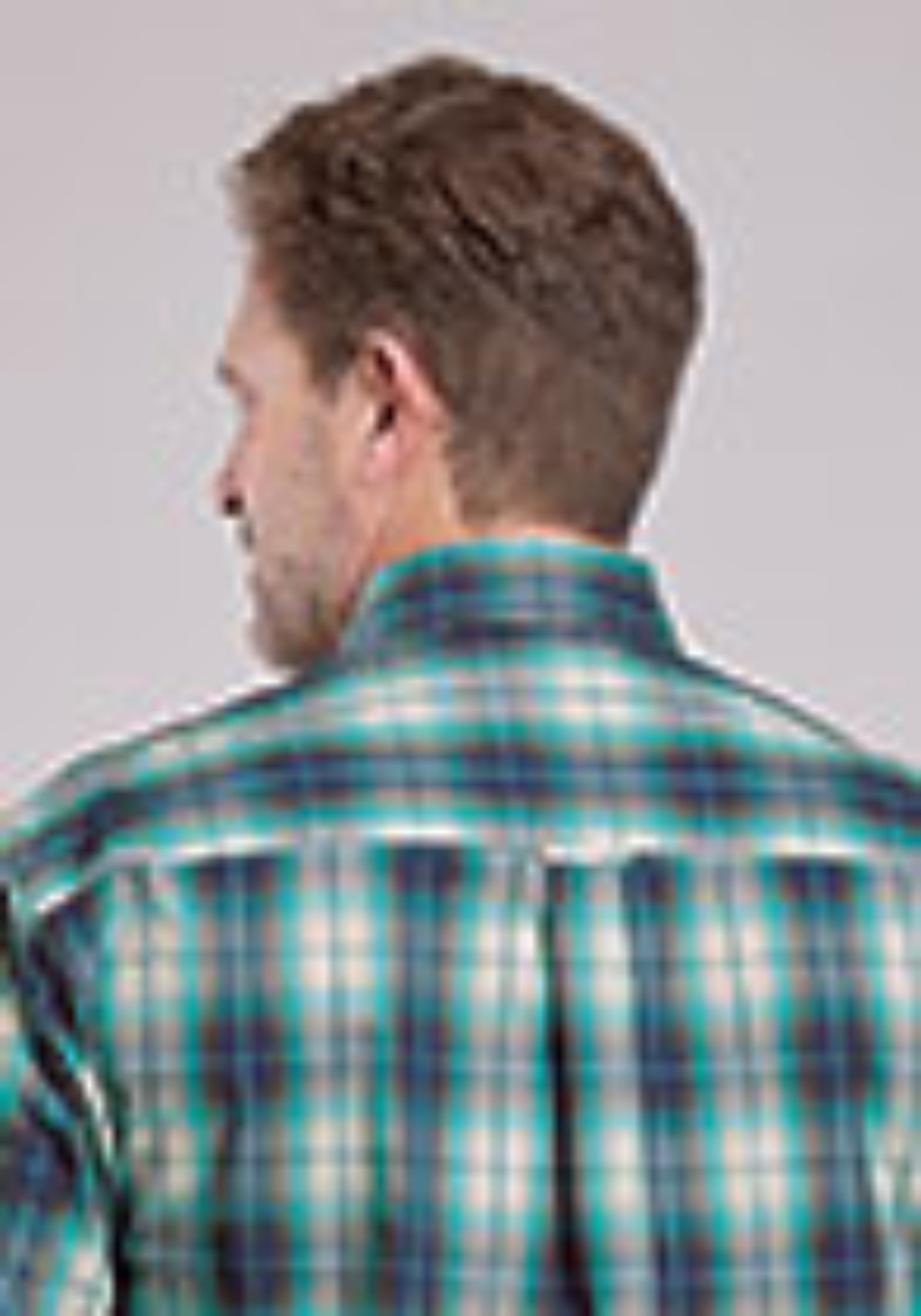 Man wearing a plaid shirt with a visible brand logo.