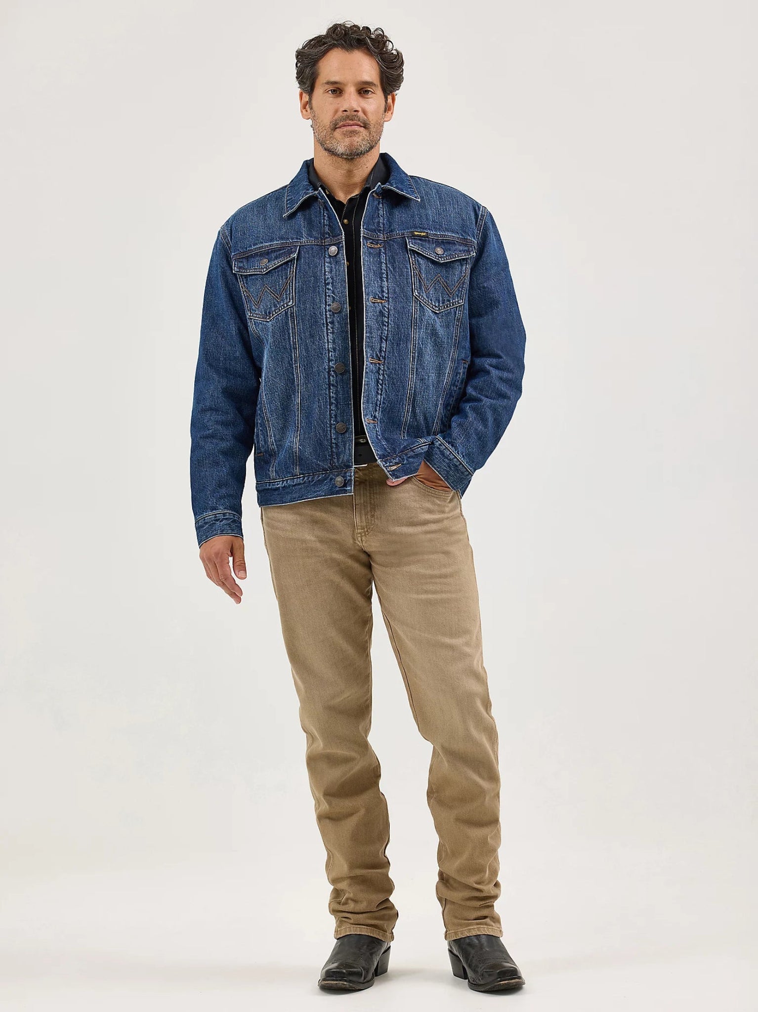 Man wearing a blue denim jacket and beige pants 