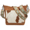 A brown and white shoulder bag with a patterned strap and a cowhide design on the front.
