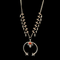 A silver squash blossom necklace with a detailed pattern and a central ornamental circular piece