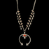A silver squash blossom necklace with a detailed pattern and a central ornamental circular piece