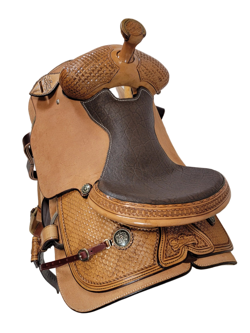 Brown leather horse saddle with intricate designs on a white background