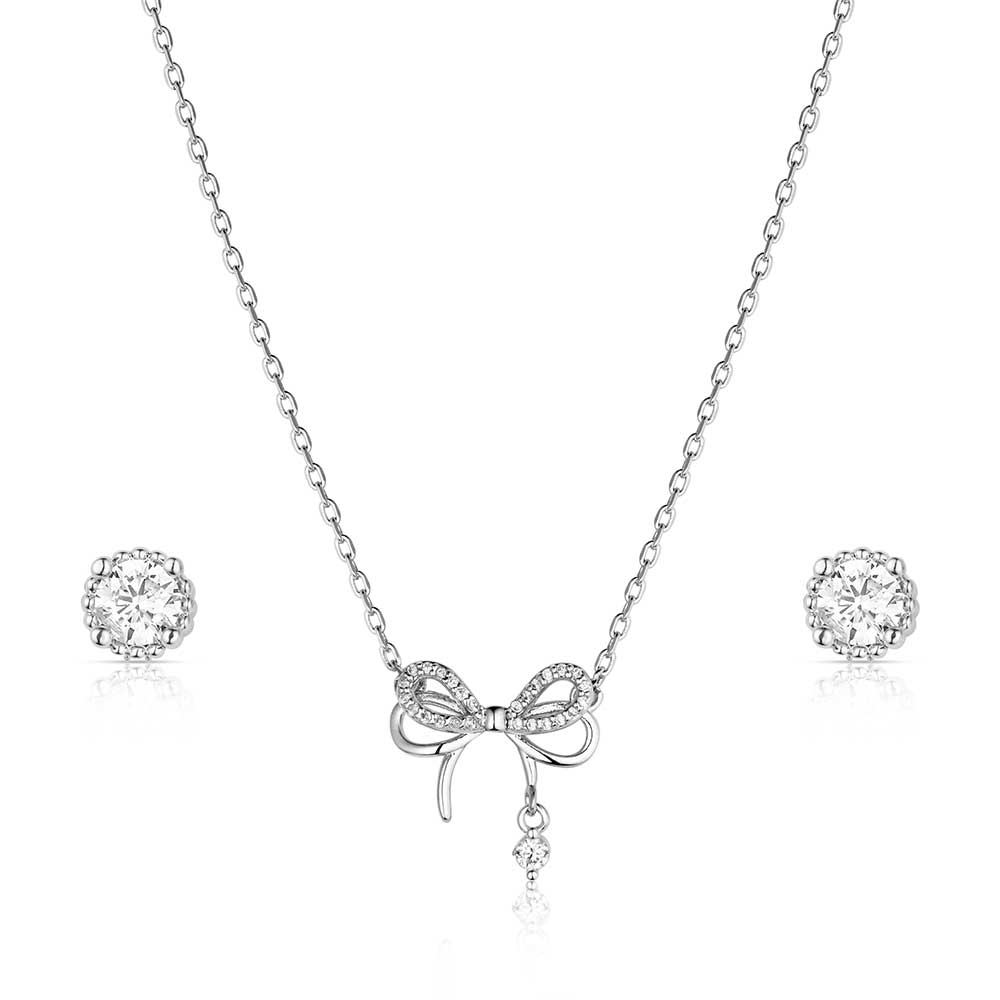 Silver bow necklace and earrings set on a white background