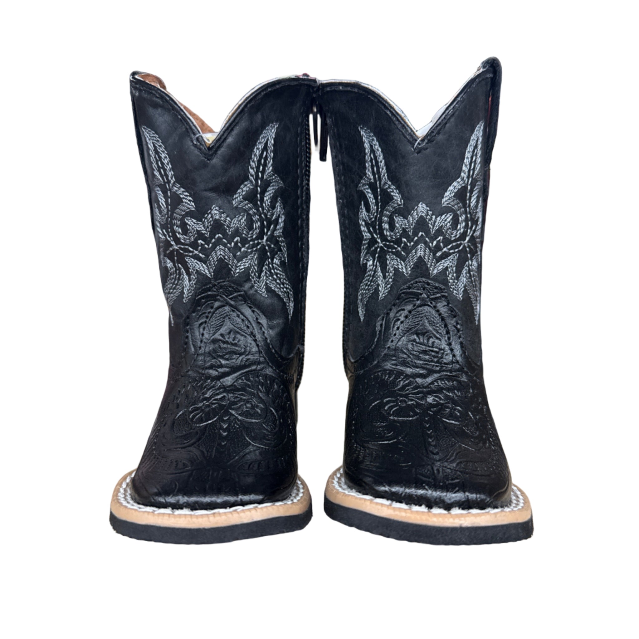 Pair of Infant black cowboy boots with intricate designs on a wooden surface and zipper sides.