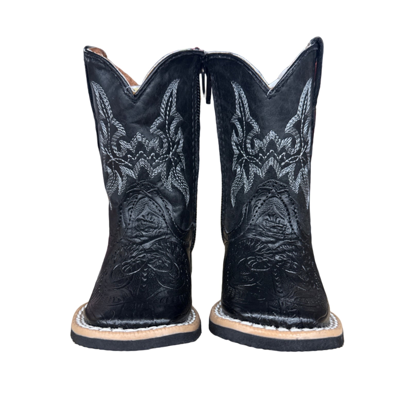 Pair of Infant black cowboy boots with intricate designs on a wooden surface and zipper sides.