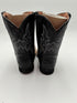 Black cowboy boots with intricate designs on a white background