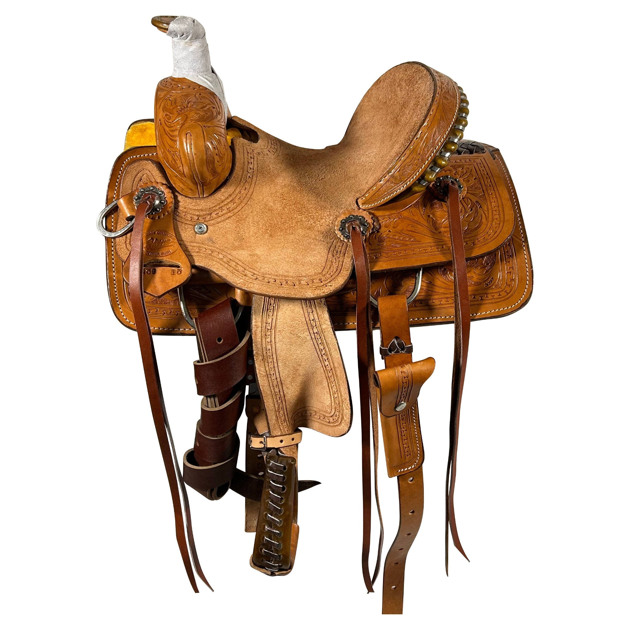 A Vickers Classic Youth saddle in brown color with detailed tooling and a light oil finish, equipped with a breast collar, strings, and a hoof pick holder.