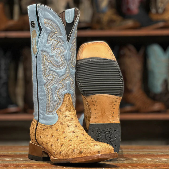 Close-up of a tan and blue cowboy boot with detailed stitching 