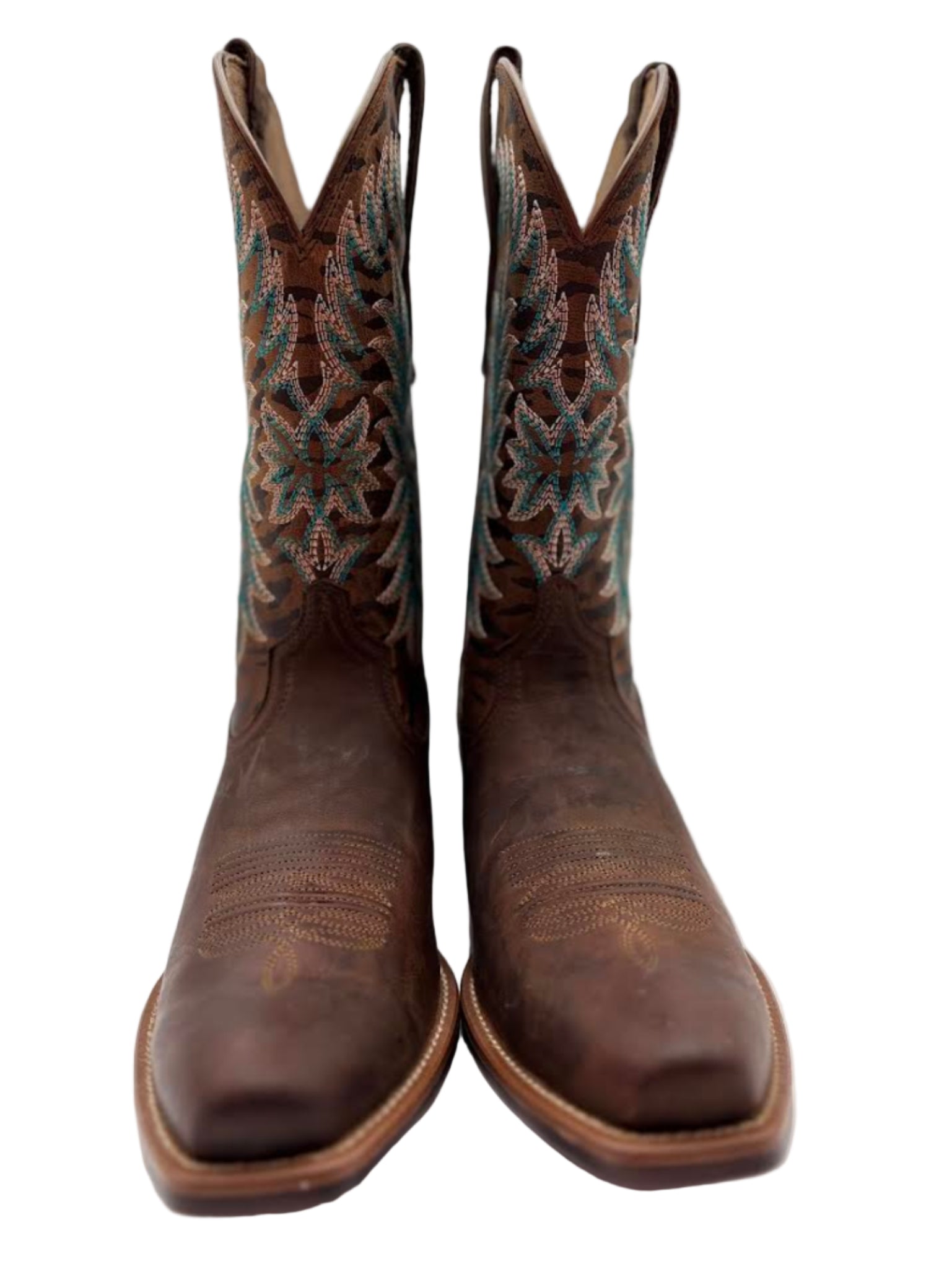 Pair of brown cowboy boots with intricate patterns on a white background