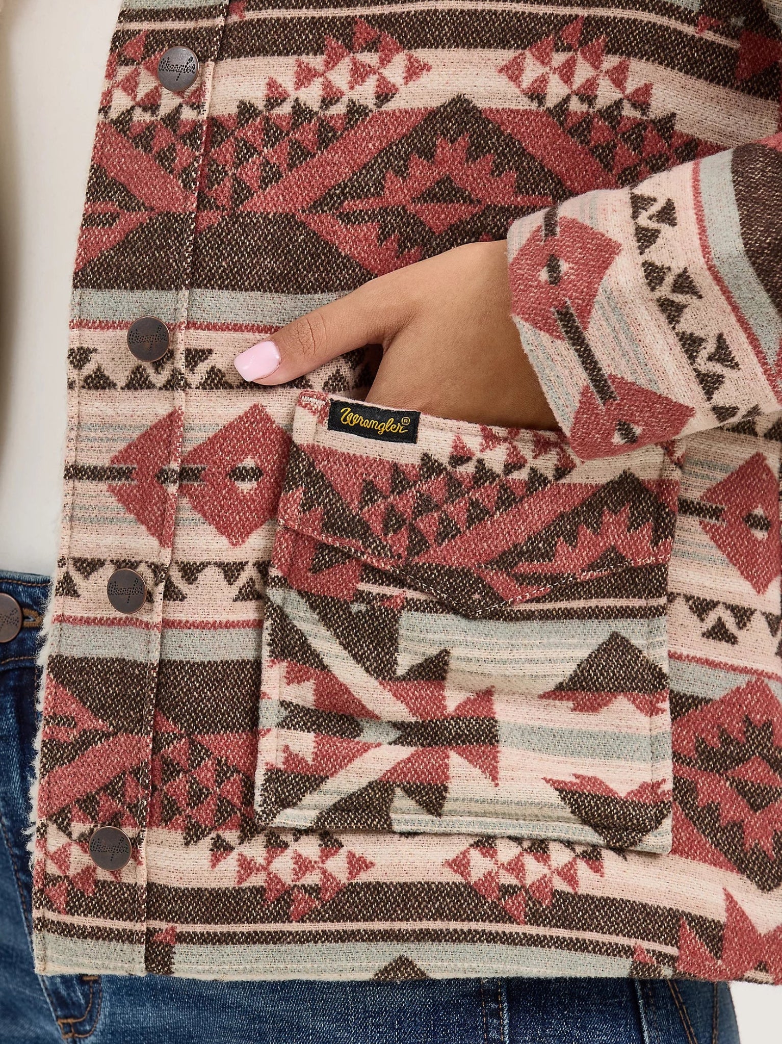 Patterned jacket with a visible Wrangler logo, worn over jeans.