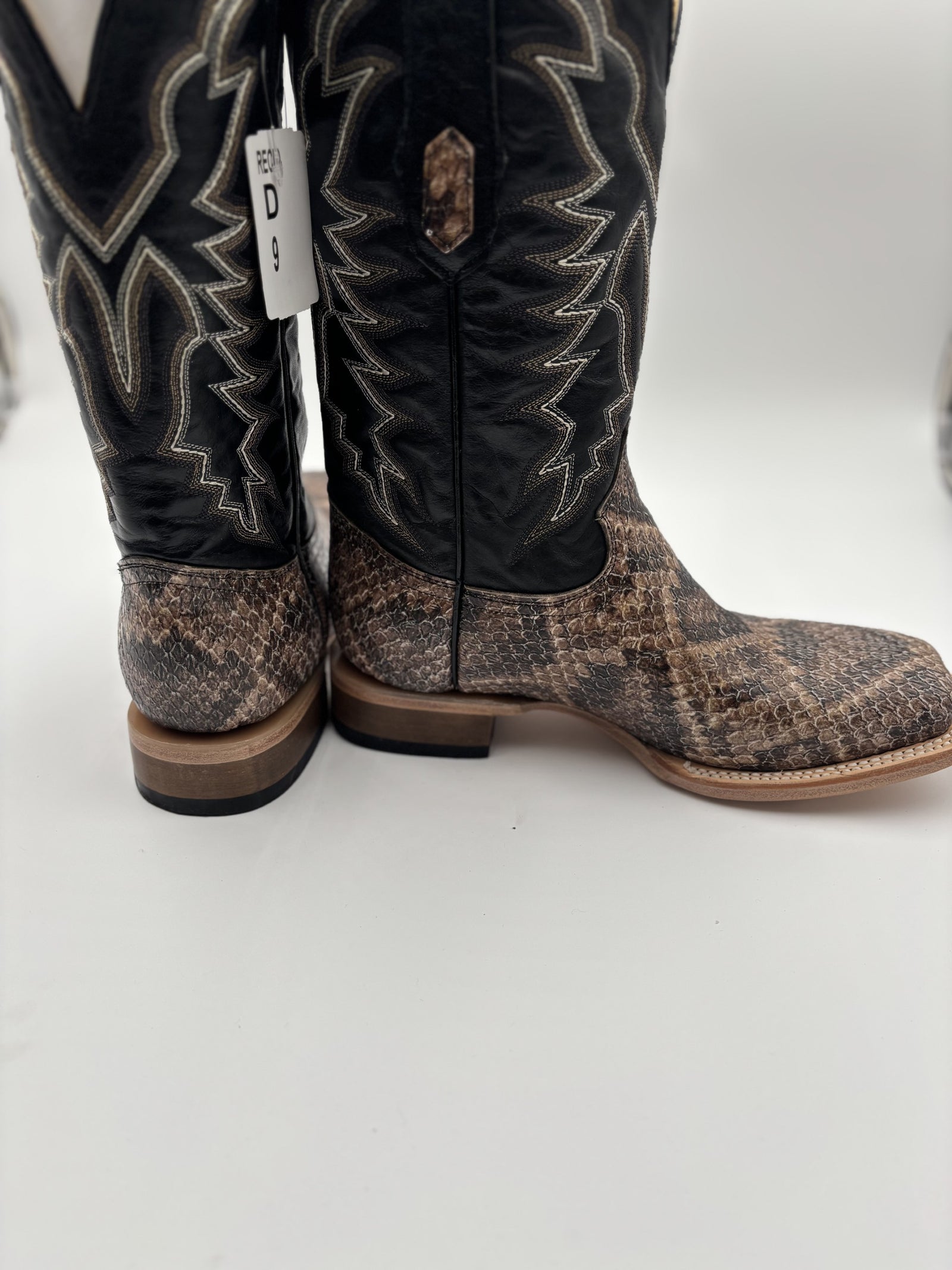 Pair of cowboy boots with a patterned sole on a white background